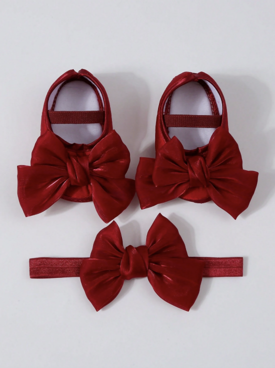 Chaussons bébé fille en velours rouge avec grands nœuds décoratifs vus de dessus