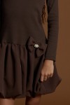 Gros plan de la broche amovible en perles sur la robe Aria chocolat