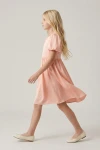 Robe Sia rose de profil – jupe évasée au-dessus du genou en mouvement