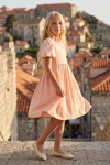 Robe Sia rose vue de côté, sur fond de toits de vieille ville