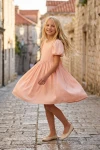 Robe Sia rose – pirouette dans une ruelle pavée de vieille ville