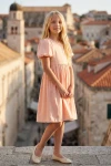 Robe Sia rose, silhouette entière devant une tour de vieille ville