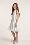 Robe Rozalia blanche plissée – vue de côté, coupe trapèze à hauteur du genou