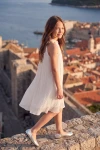 Robe Rozalia blanche plissée sur des remparts – vue de côté