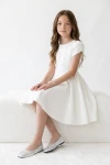Robe Rumi blanche – assise sur un banc blanc, vue de face