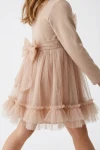 Robe Iga beige vue de côté – grand nœud en tulle dans le dos et volants au bas de la jupe
