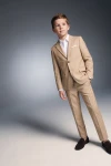 Costume garçon Liam beige – veste boutonnée, main dans la poche, vue de trois quarts