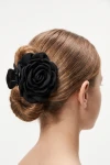 Pince crabe à fleur noire portée dans un chignon bas – vue de dos