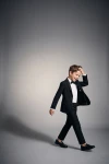 Costume garçon Sam noir avec nœud papillon – en mouvement sur fond gris, veste ouverte